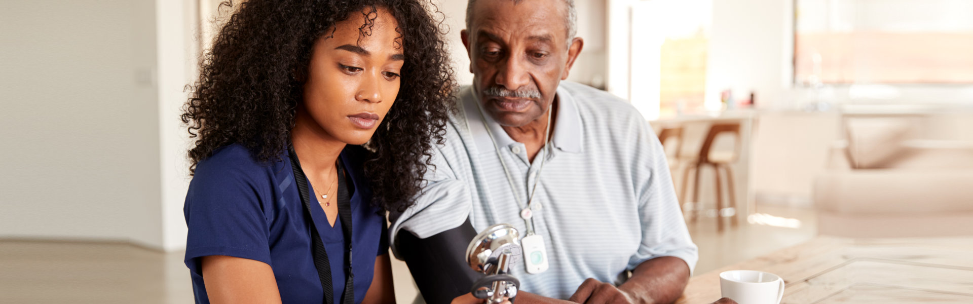 Female healthcare worker checking the blood pressure of a senior man