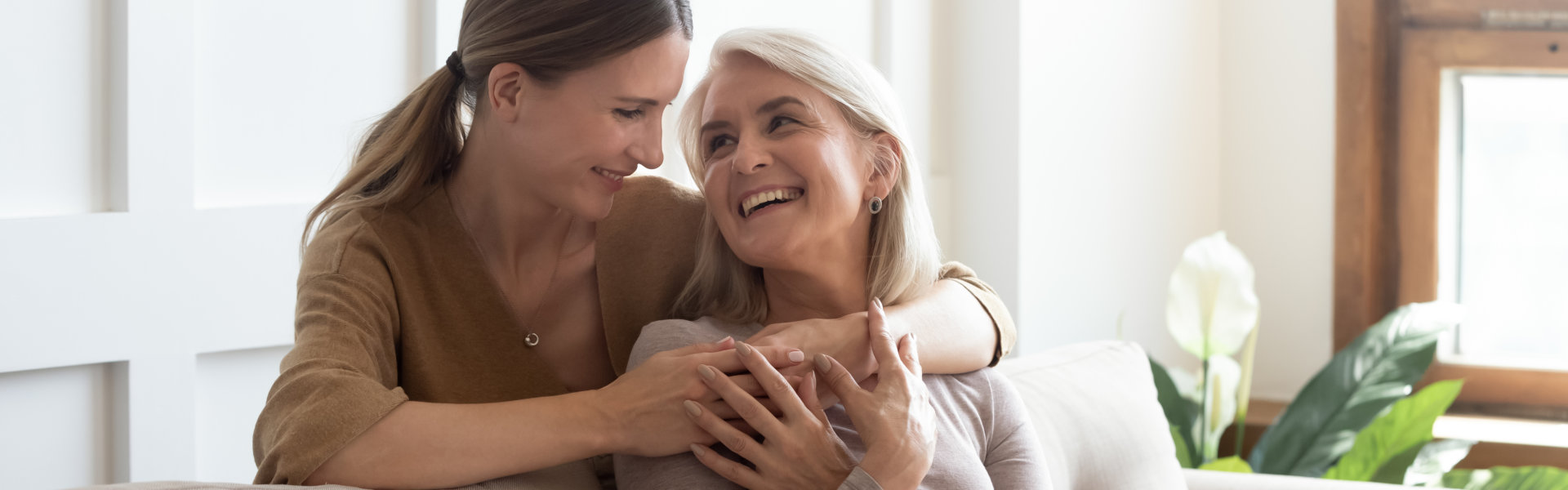 Loving adult daughter hugging the senior mother