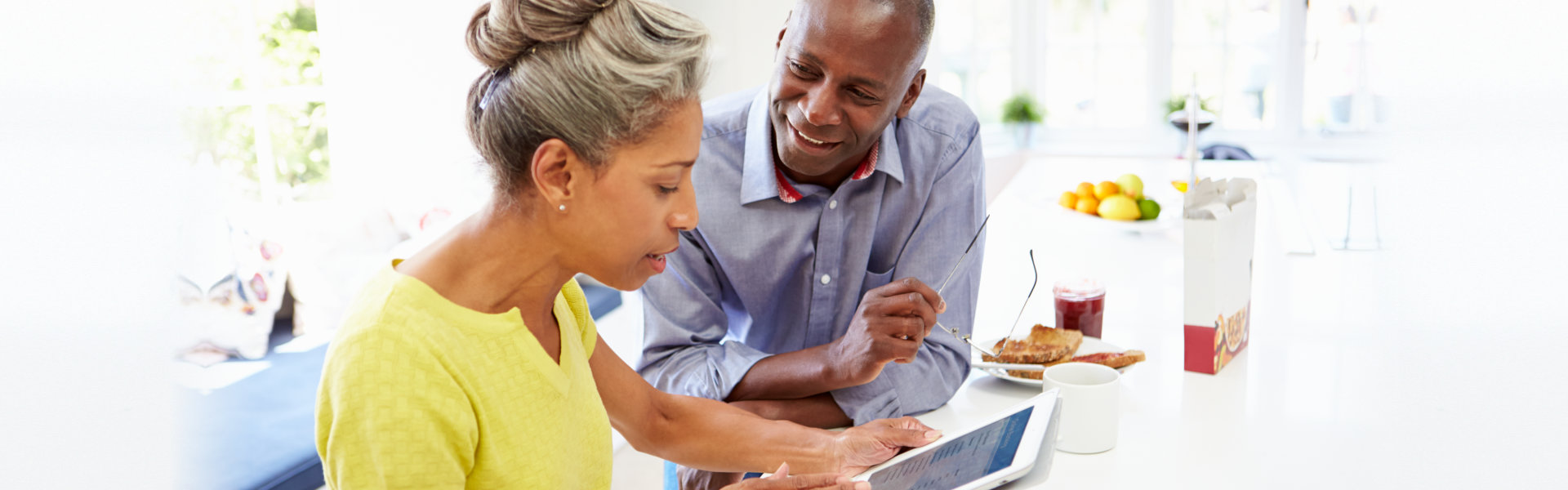 a couple using digital tablet at home sitting down searching the web